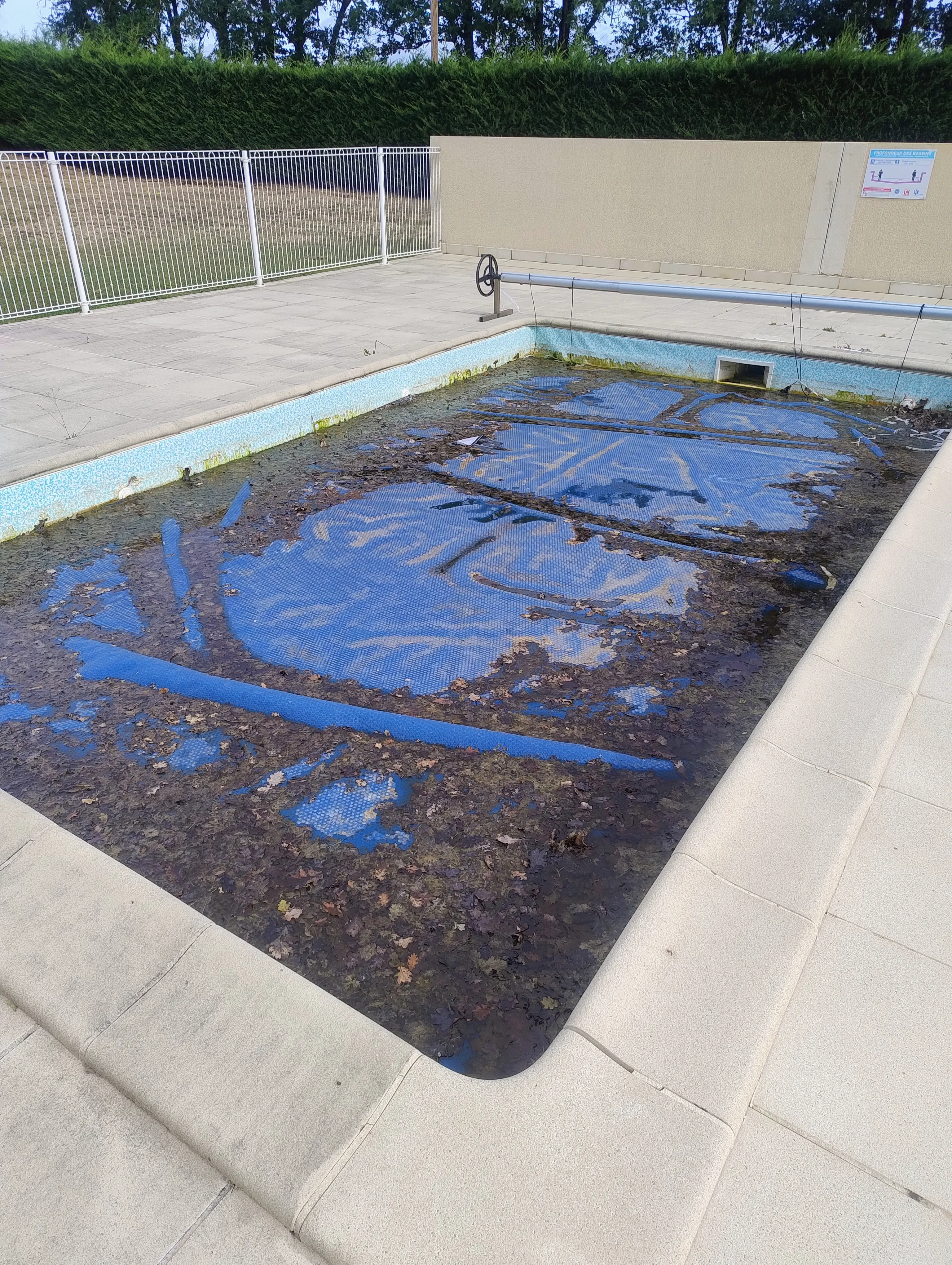 Piscine verte couverte bâche abîmée