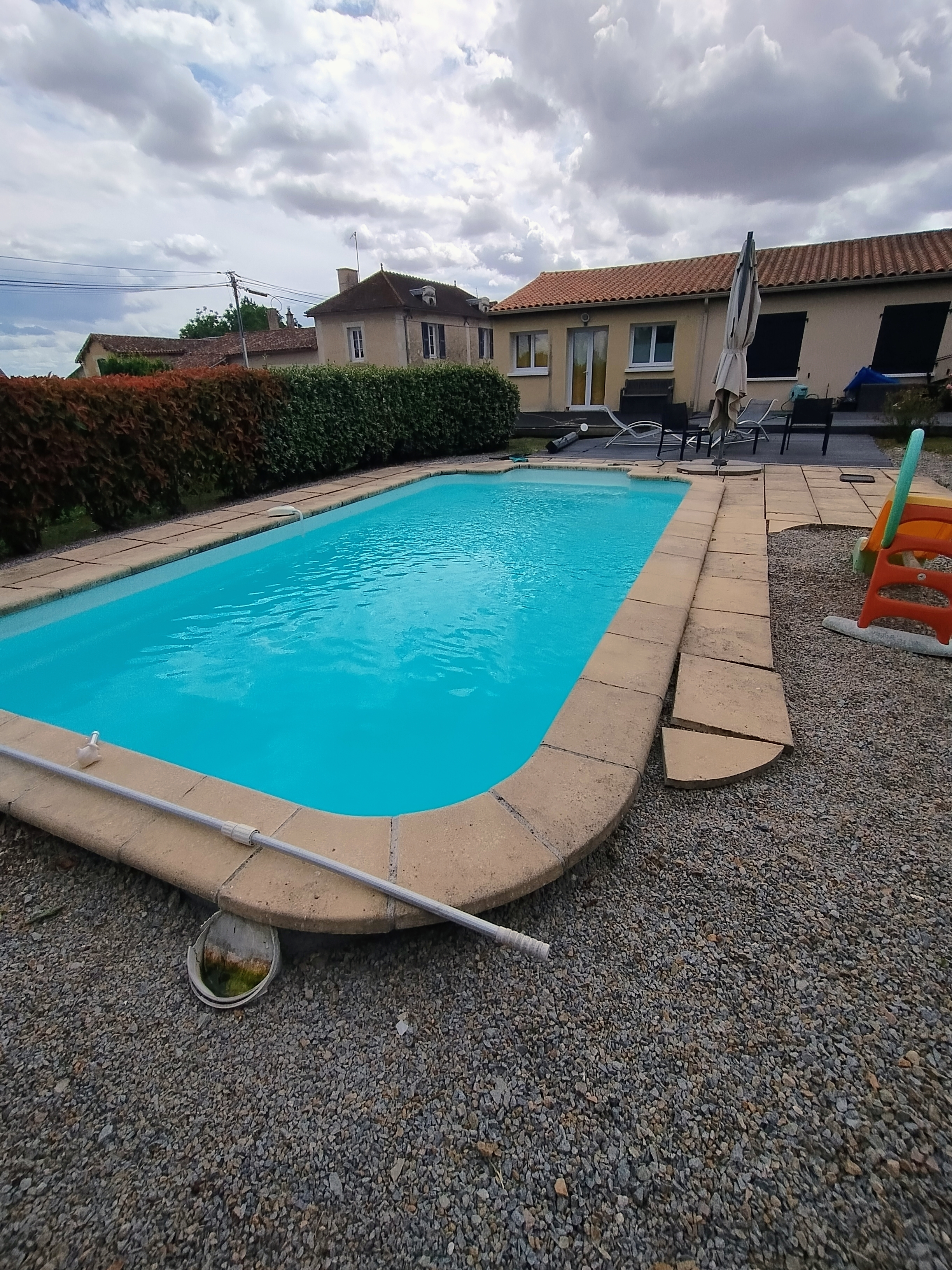 Piscine bleue avec maison en fond